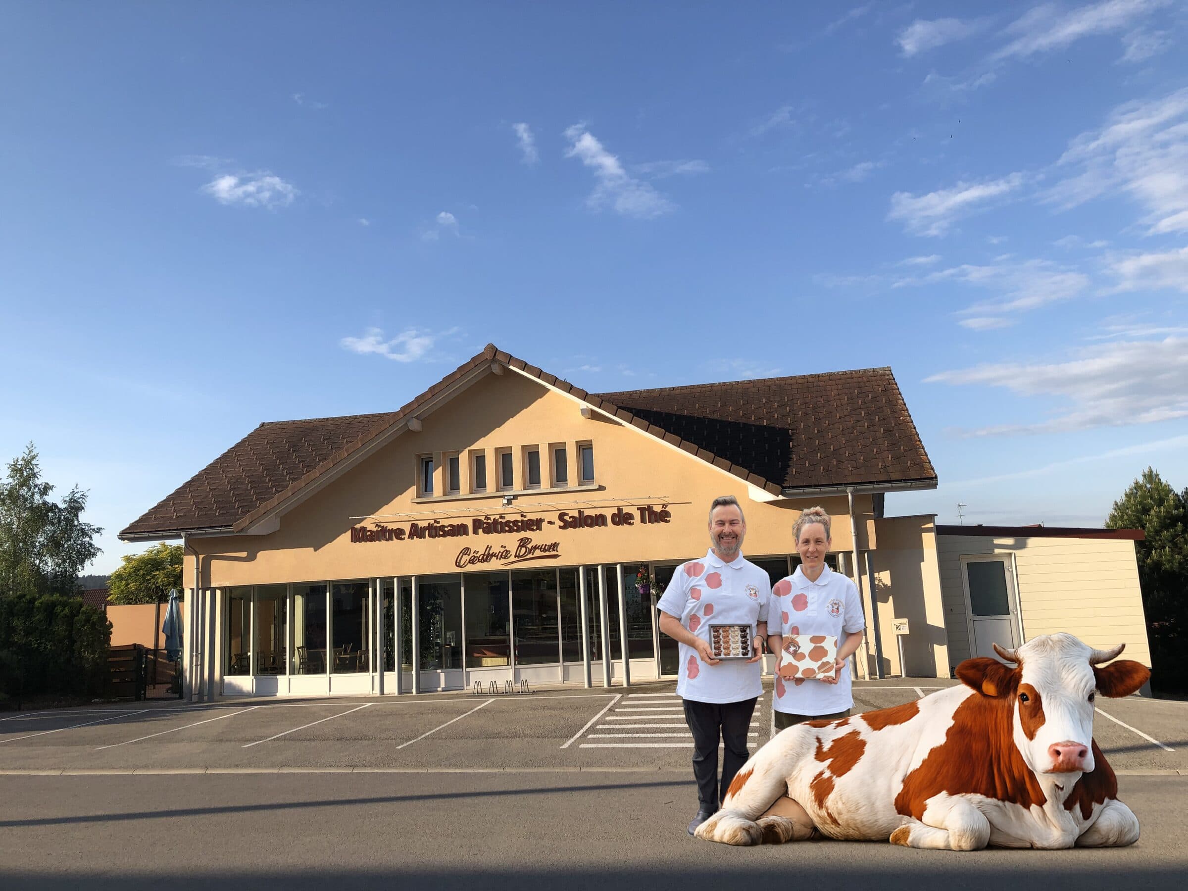 Mélanie et Cédric Brun devant la boutique, avec une vache montbéliarde et leurs coffrets